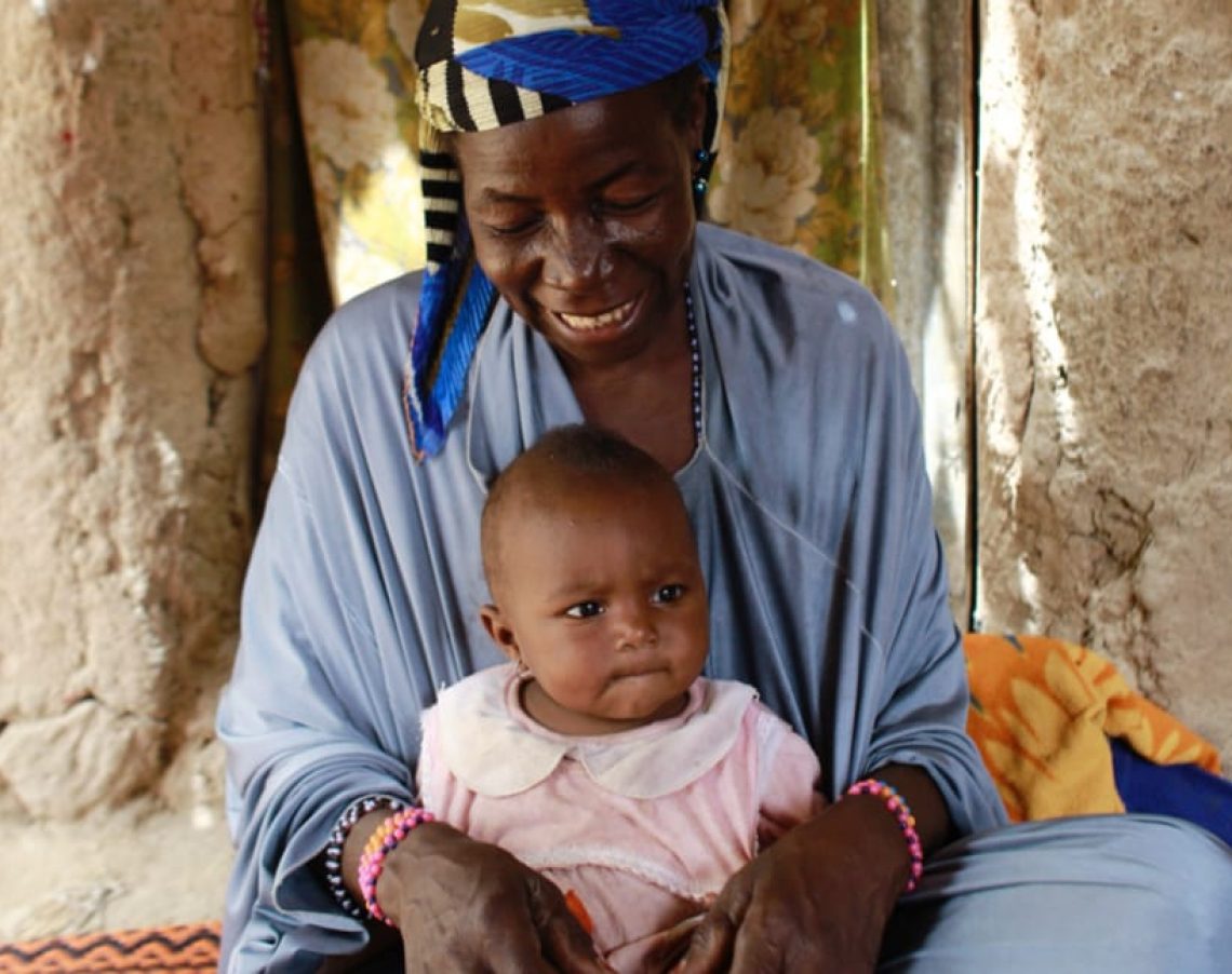 CARE/Josh Estey - Proud mother with a healthy child in one of CARE project villages.